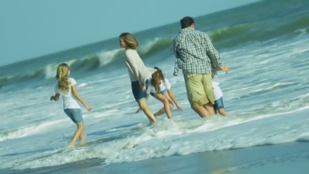 Eltern mit Töchtern spielen am Strand — Stockvideo