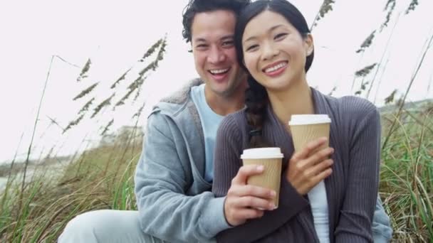 コーヒーを飲みながらビーチでの休暇をカップルします。 — ストック動画