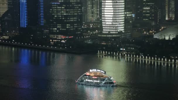 Stad gebouwen en verlichte toeristische boten — Stockvideo