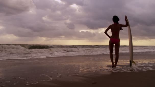 Девушка на пляже с доской для серфинга — стоковое видео