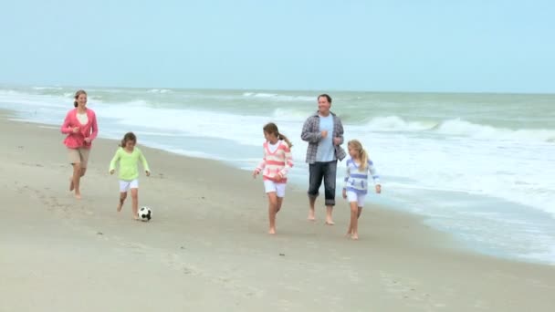 Rodzina kopiąc piłkę na plaży — Wideo stockowe