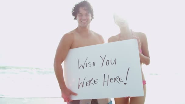 Couple on beach with white board — Stock Video