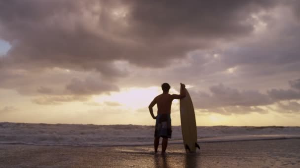 Surfista en la playa viendo olas — Vídeo de stock