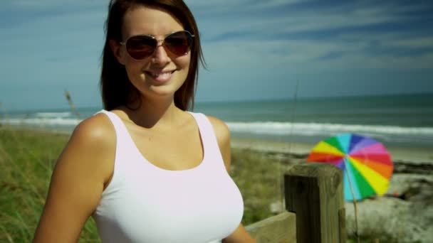 Kobieta na plaży uśmiechając się do kamery — Wideo stockowe