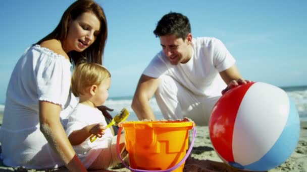 Eltern mit Sohn spielen am Sandstrand — Stockvideo