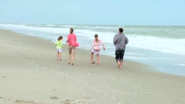 Family kicking ball on beach — Stock Video