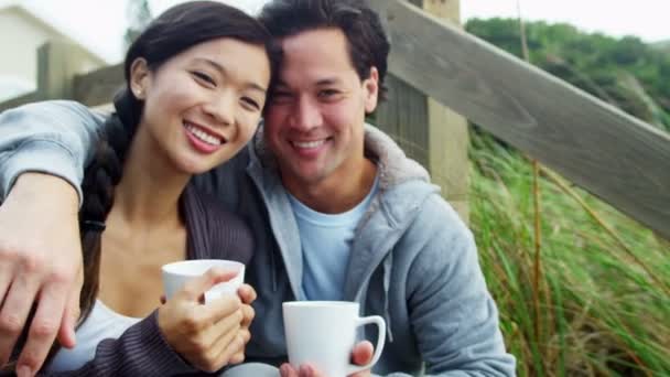 Couple on beach drinking coffee — Stock Video
