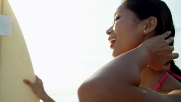 Flicka anläggning surfbräda på stranden — Stockvideo