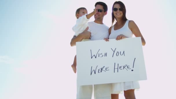 Οικογένεια στην παραλία κρατώντας το μήνυμα του σκάφους — Αρχείο Βίντεο