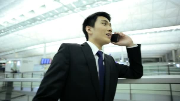 Бизнесмен в аэропорту разговаривает на смартфоне — стоковое видео