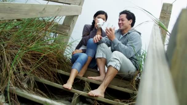 Pareja en la playa bebiendo café — Vídeos de Stock