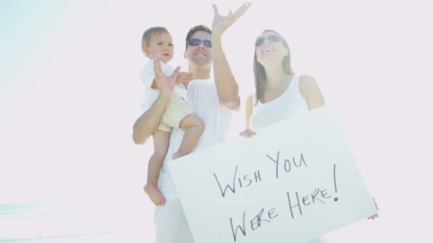 Famiglia sulla spiaggia tenendo bordo messaggio — Video Stock