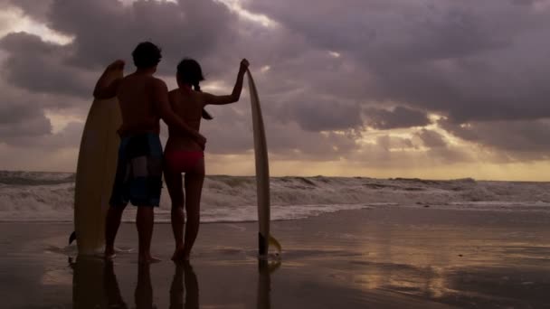 Couple avec planche de surf sur la plage — Video