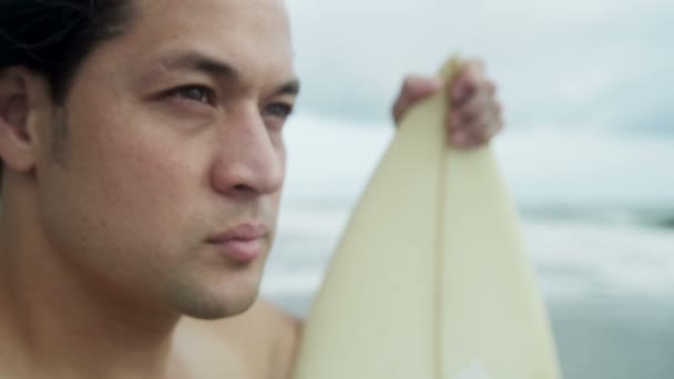 Homme avec planche de surf regardant les vagues — Video