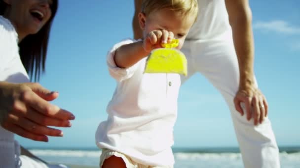 Eltern mit Sohn spielen am Sandstrand — Stockvideo