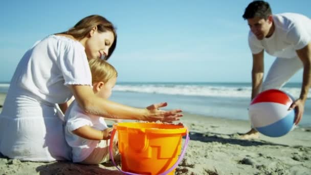 Padres con hijo jugando en la playa de arena — Vídeos de Stock