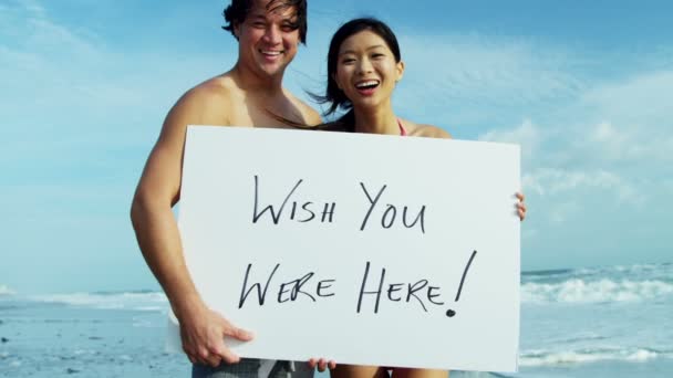 Pár na pláži s bílou tabuli — Stock video