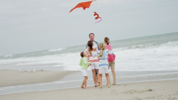 Familia con cometa voladora en la playa — Vídeo de stock