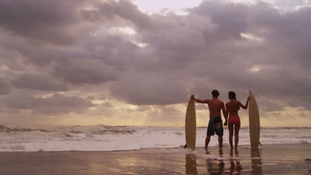 Pareja con tabla de surf en la playa — Vídeos de Stock