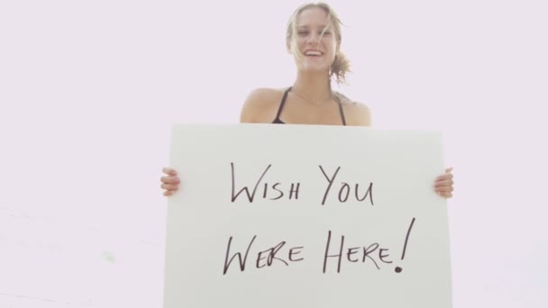 Девушка в бикини держит доску объявлений — стоковое видео