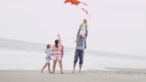 Familia con cometa voladora en la playa — Vídeo de stock