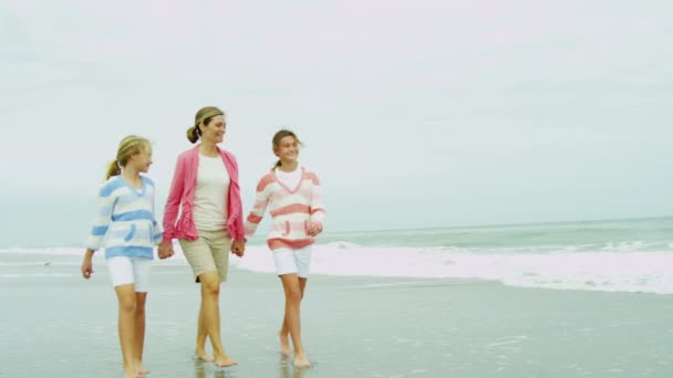 Мать с дочерьми, гуляющими по пляжу — стоковое видео