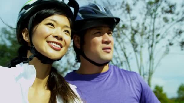 Feliz pareja étnica ciclismo juntos al aire libre — Vídeo de stock