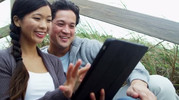 Couple sur la plage avec tablette sans fil — Video