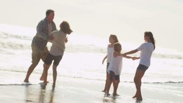 Padres con hijas jugando en la playa — Vídeo de stock