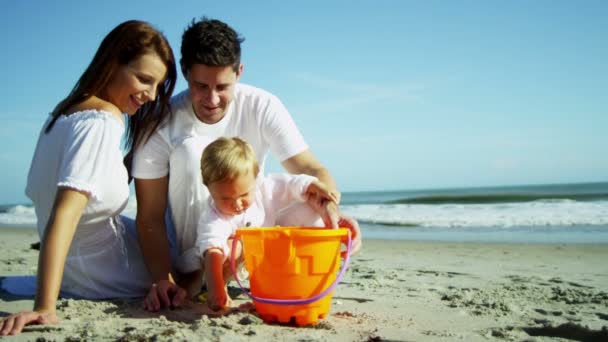 Parents avec fils jouant sur la plage de sable fin — Video