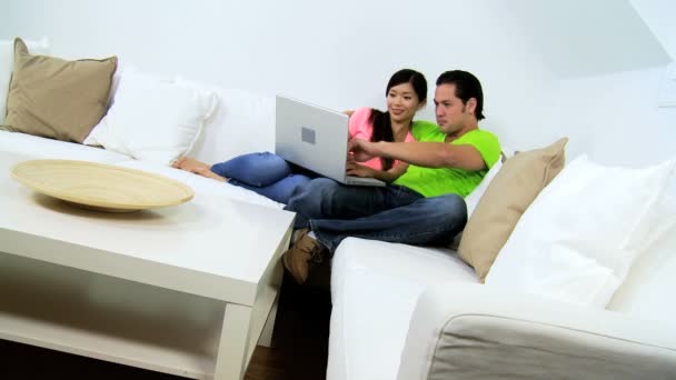 Casal usando laptop no sofá — Vídeo de Stock