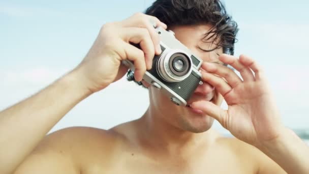 Uomo sulla spiaggia utilizzando la fotocamera — Video Stock