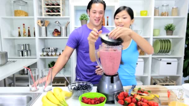 Pareja haciendo casero smoothie juntos — Vídeos de Stock