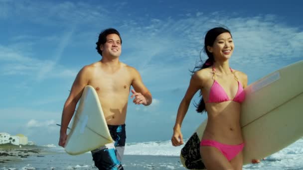 Surfing couple running beside ocean — Stock Video