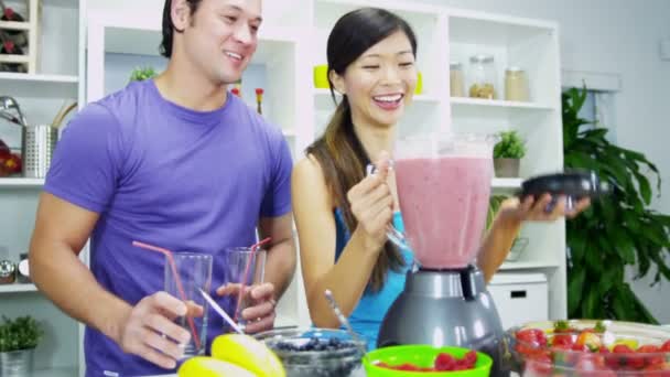 Pareja haciendo nutritiva bebida fresca de zumo de fruta casero — Vídeo de stock