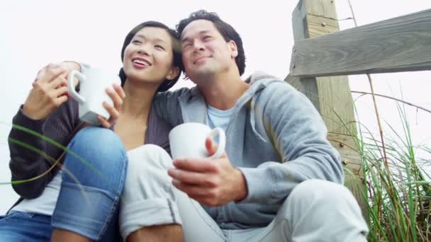 Pareja en la playa bebiendo café — Vídeos de Stock