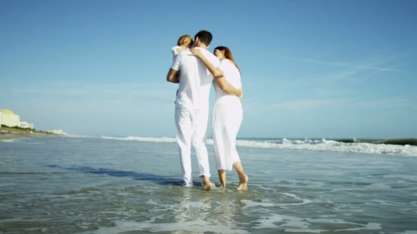 Ouders met baby wandelen op het strand — Stockvideo