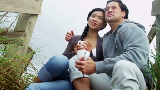 Pareja en la playa bebiendo café — Vídeos de Stock