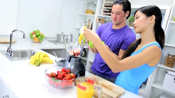 Hombre y mujer haciendo jugo de fruta fresca — Vídeos de Stock