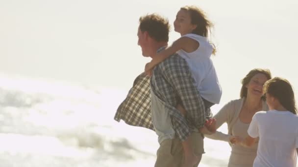 Батьки з дочками грають на пляжі — стокове відео