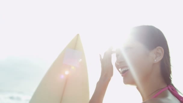 Flicka anläggning surfbräda på stranden — Stockvideo