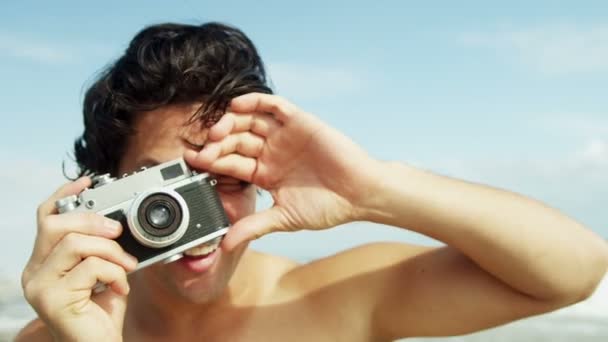 Hombre en la playa usando la cámara — Vídeos de Stock