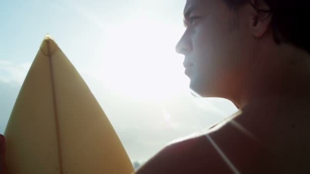 Hombre sosteniendo tabla de surf en la playa — Vídeo de stock