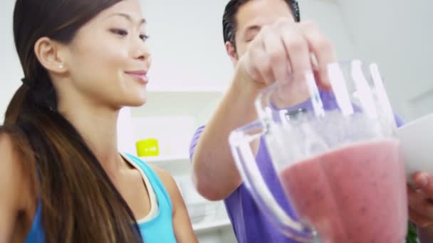 Pareja haciendo delicioso batido de frutas orgánicas — Vídeos de Stock