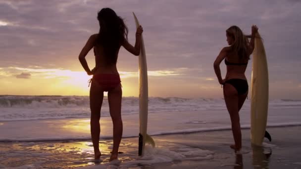 Girls holding surfboards on beach — Stock Video