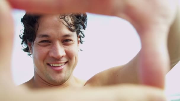 Hombre en la playa haciendo marco de dedo — Vídeo de stock