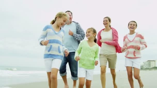 Familie läuft barfuß am Strand entlang — Stockvideo