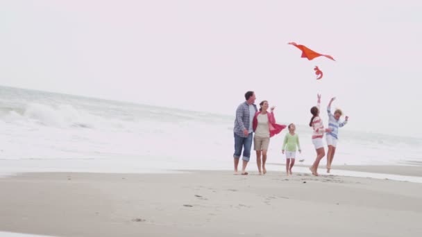 Familie met vliegende kite op strand — Stockvideo