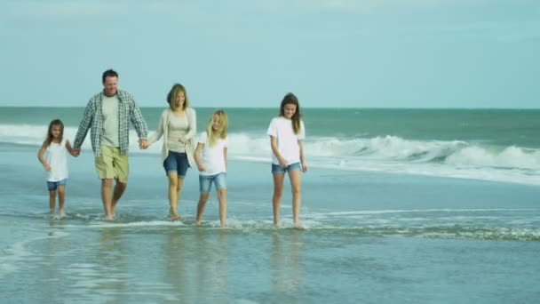 Padres con hijas caminando en la playa — Vídeo de stock