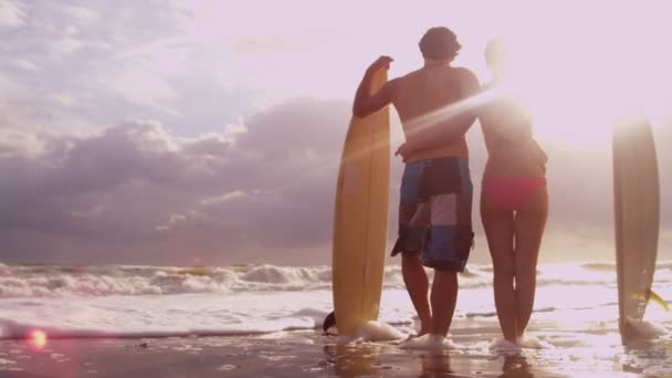 Couple au coucher du soleil regardant les vagues de l'océan — Video